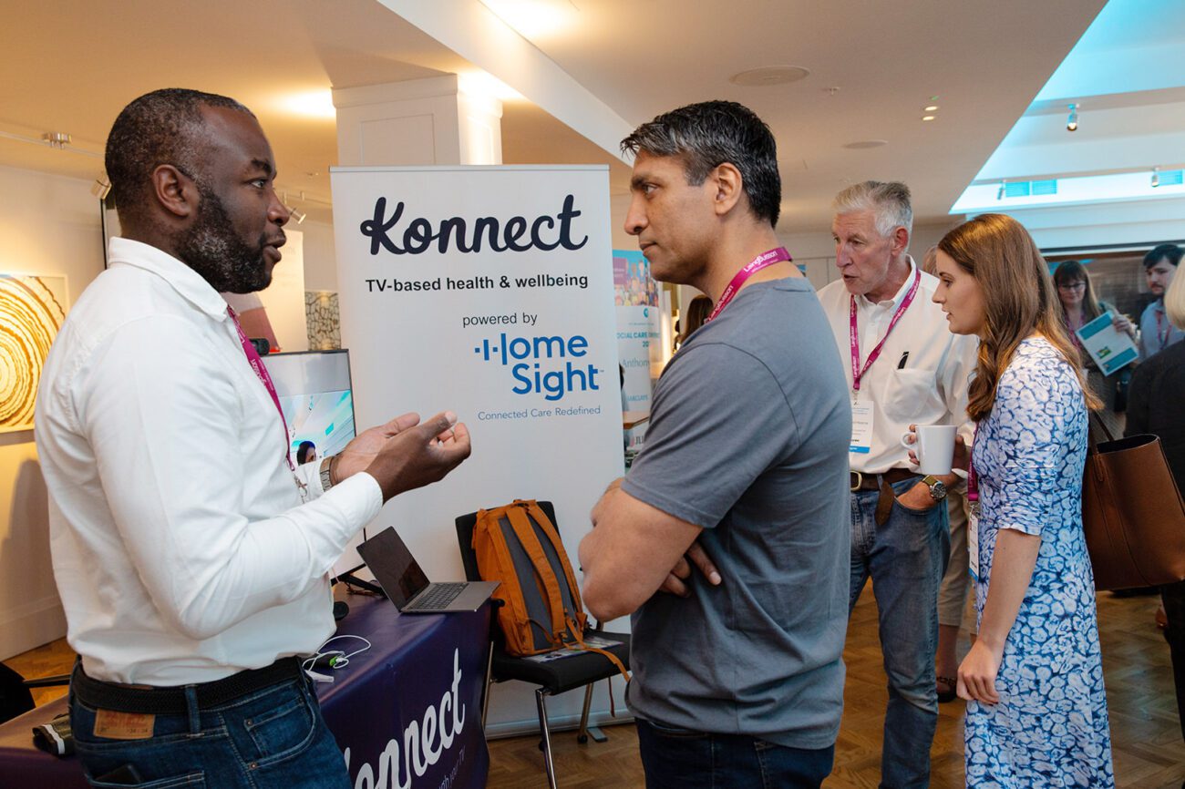 Conference photography delegates engage with one of the conference sponsors at their stand in the exhibition hall