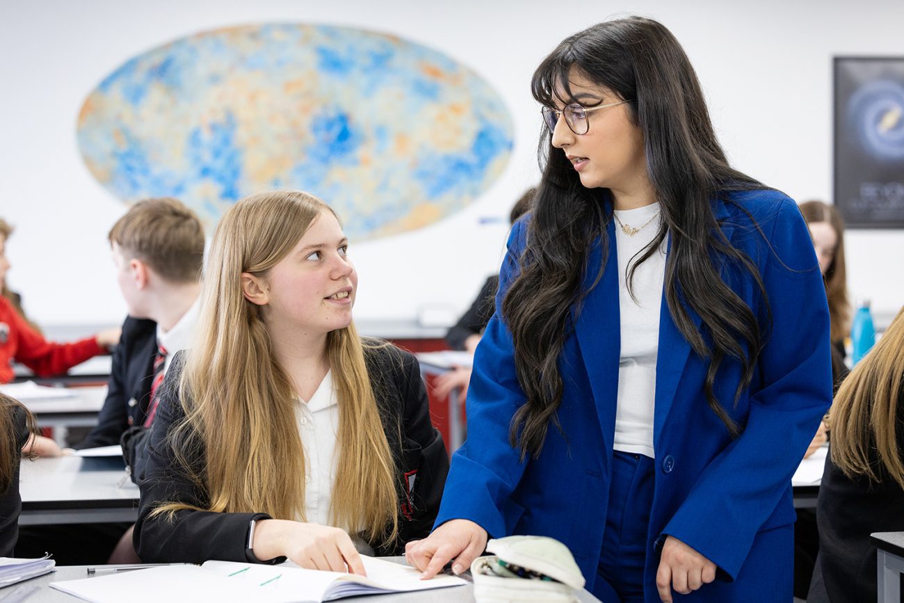 A teacher helps an student during a Science lesson taking place at Alexandra Park School in North London